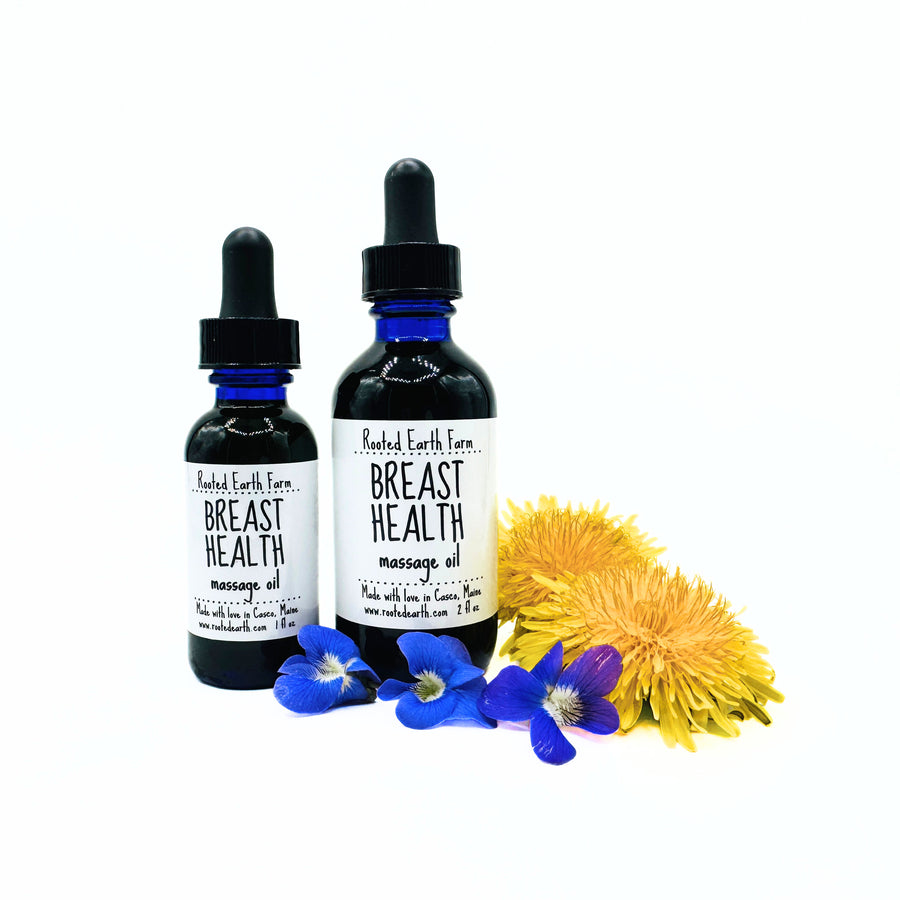 Two bottles of 'Breast Health' massage oil with flowers on a white background