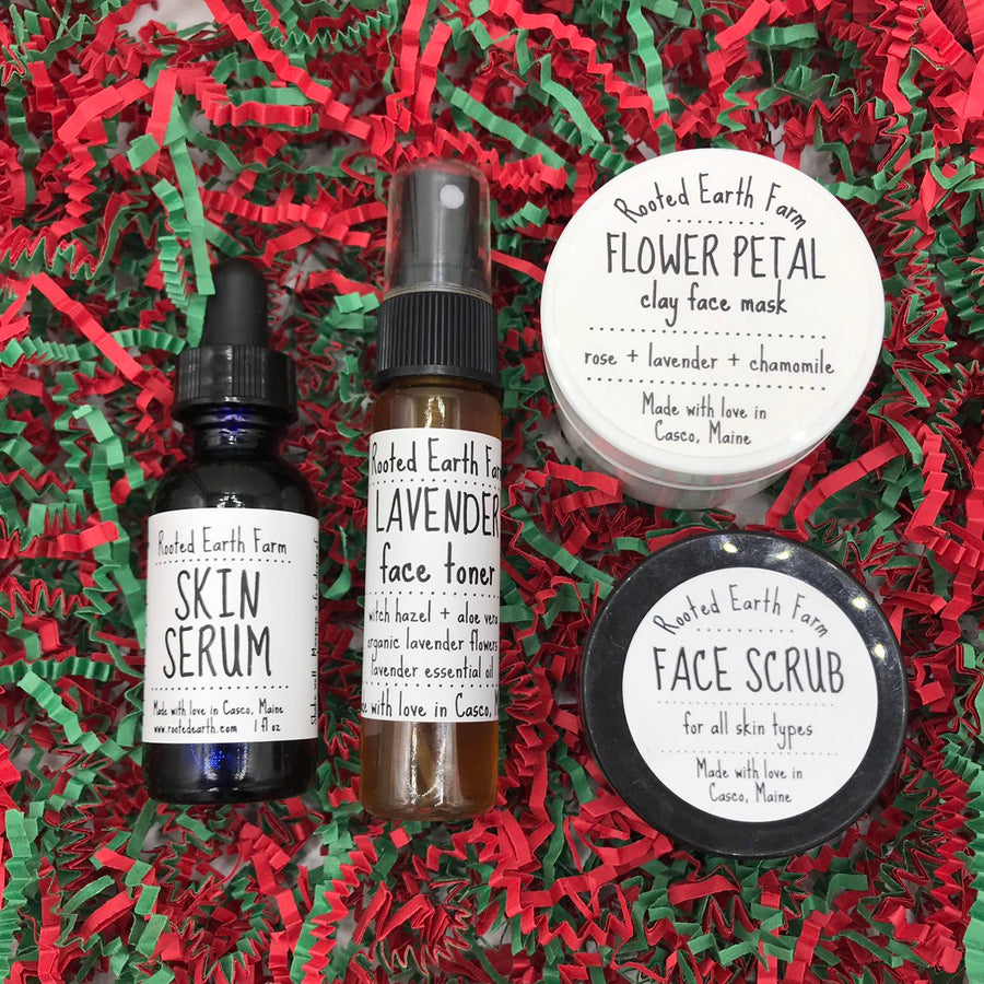 A natural skin care gift set that includes lavender face toner, herbal skin serum, flower petal clay face mask and herbal face scrub